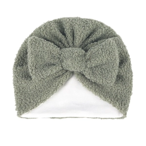 Détail du bonnet pour bébé en velours teddy vert sauge avec nœud et doublure douce blanche