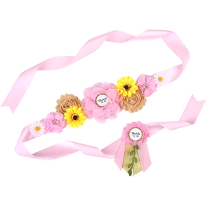 Detailed view of Mom to Be sash and Daddy to Be badge with pink flowers and sunflowers
