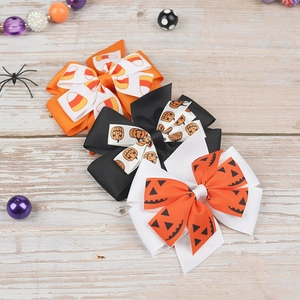 Detailed set of Halloween hair clips with pumpkin and candy corn prints on grosgrain ribbon