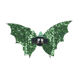 Detail of green glitter bat wing hair clip with a cute cartoon spider in wizard hat