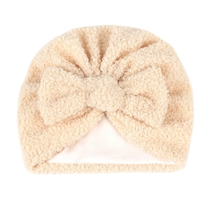 Détail de la doublure en polaire douce et du nœud en peluche sur ce bonnet chaud pour bébé