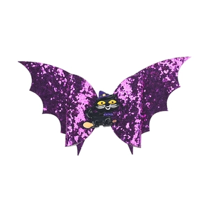 Detail of purple glitter bat wing hair clip with a black cat witch centerpiece