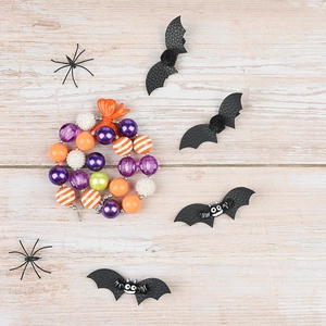 Flat lay of Halloween jewelry set with beaded necklace, leather bats and black spiders