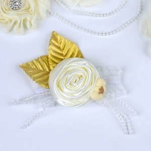 Detail showing the cream satin rose flower with gold leaves and pearl chain on wedding belt