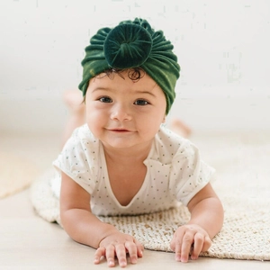 Dark green velvet baby turban hat with circular knot design for infants winter warmth