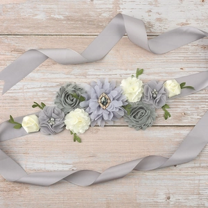 Detail of elegant handmade maternity belt with grey silk ribbon and fabric flowers