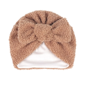 Détail du bonnet pour bébé en polaire marron avec un grand nœud et doublure chaude