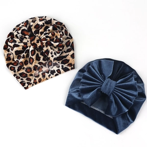 Flat lay of leopard print and navy velvet baby turbans with large bow details