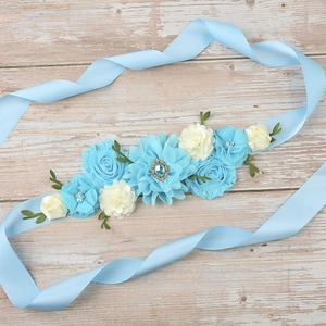 Detail of baby shower maternity sash with light blue fabric flowers and rhinestones