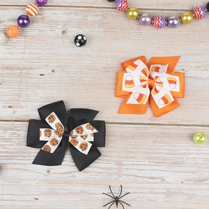 Detail of Halloween hair bows set with pumpkin and candy corn prints on wood background