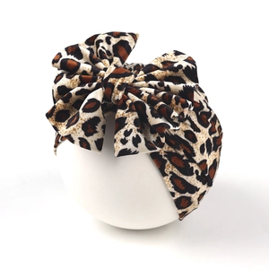 Detail of baby turban hat featuring a large leopard print bow and soft knit fabric