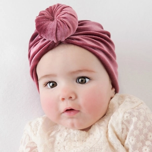 Close-up of rose pink velvet infant turban hat featuring a soft donut knot design