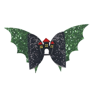 Detail of Halloween hair clip with green glitter bat wings and black castle motif