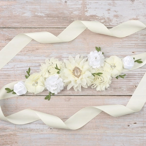 Detail of handmade maternity sash featuring ivory chiffon roses and green fabric leaves