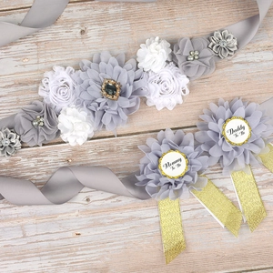 Detail of silver grey floral maternity sash and matching Daddy and Mommy To Be badges