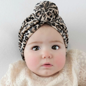 Detail shot of infant leopard print knot hat featuring a donut-style turban design
