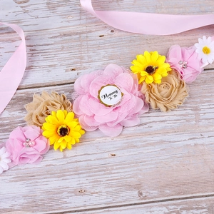 Detailed close-up of Mommy To Be maternity sash with pink and yellow floral accents