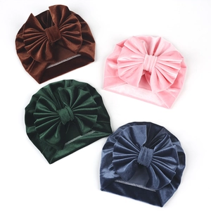 Set of four velvet baby hats with large bows in brown, pink, dark green, and blue gray