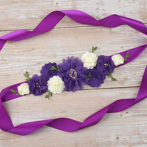 Detail of floral maternity sash with purple ribbon and fabric dahlia flowers