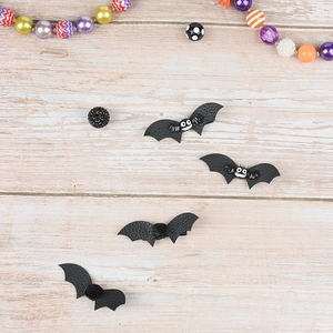 Close-up of Halloween bat hair clips with black leather texture and cartoon eyes