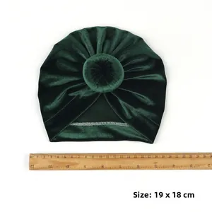 Detail of dark green velvet baby donut hat showing the knot texture and 19x18 cm size