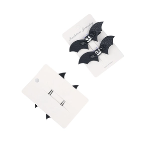 Detail view of Halloween bat hair clips with black faux leather texture on white card