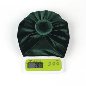 Detailed view of dark green velvet baby turban hat showing 28.9g lightweight material