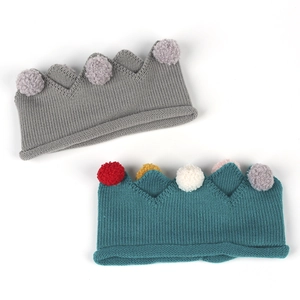 Détail du bandeau couronne tricoté pour bébé avec laine souple et pompons multicolores