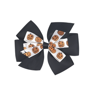Detailed view of Halloween baby headband with layered black and pumpkin pattern bows