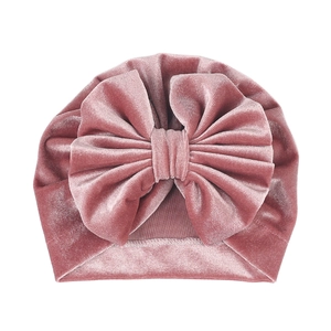 Detail of baby velvet turban hat with large double-layered bow in dusty rose pink