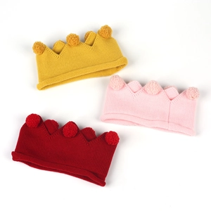 Détails des bonnets tricotés en forme de couronne en jaune, rose et rouge avec pompons