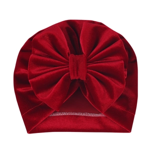 Detail of red velvet baby turban hat showing fine stitching and large bow texture