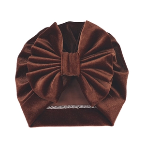 Detail of coffee brown velvet baby turban hat with a large decorative bow and fine stitching