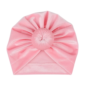 Detailed view of pink velvet baby turban hat with top knot and pleated texture