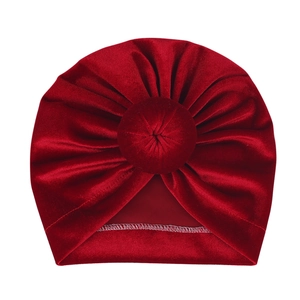 Detail view of dark red velvet baby turban hat featuring a round knot and soft texture