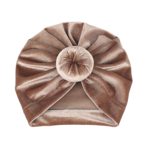 Close-up of baby donut turban hat in light brown velvet with pleated texture