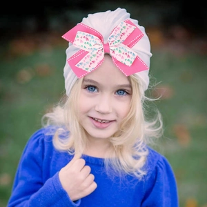 Bonnet turban blanc pour bébé avec un double nœud rose à motifs de cœurs