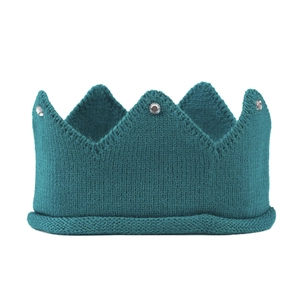 Detailed knit texture of a peacock green baby crown hat with sparkling rhinestone accents