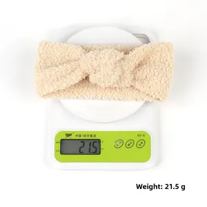 Nahaufnahme eines beigen Teddy-Fleece-Stirnbandes mit einem Gewicht von 21,5 g auf Waage