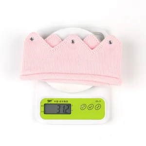 Detailed view showing the 31.2g weight of a pink knitted baby crown with rhinestones