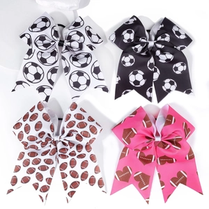 Set of four grosgrain hair bows featuring soccer and football prints in vibrant colors