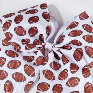 Detail of white grosgrain ribbon hair bow with American football print and textured fabric