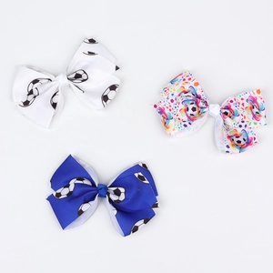 Three soccer-themed grosgrain ribbon bow clips in white, blue, and colorful ink patterns