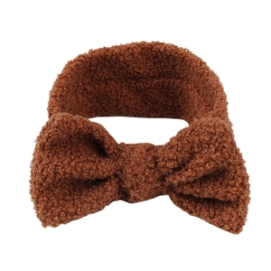 Nahaufnahme der weichen braunen Teddy-Fleece-Textur und Plüschschleife am Kinderstirnband