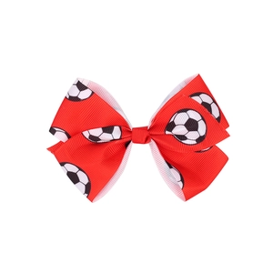 Detailed macro view of red grosgrain soccer bow hair clip with black and white football print