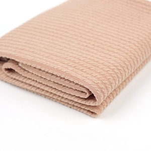 Gros plan sur la texture gaufrée de la couverture d'emmaillotage marron clair pour bébé