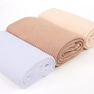Détail d'un ensemble de langes pour bébé en maille gaufrée avec motifs de torsades doux