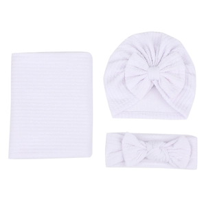 Détail de la couverture bébé en maille gaufrée lavande avec bonnet et bandeau à nœud