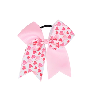 Détail d'un nœud papillon rose et blanc à motifs cœurs avec élastique noir
