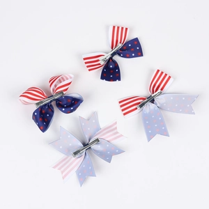 Détail de quatre barrettes pour enfants avec motifs du drapeau américain et nœuds